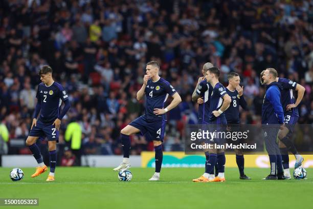 Scott McTominay of Scotland waits around next to teammates for play to resume during a suspension in play due to pitch conditions in the UEFA EURO...
