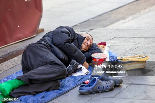 homless senior man sleeping on the street with his belongings, background with copy space - lost sock stock pictures, royalty-free photos & images