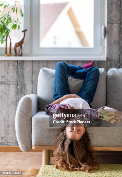 ein teenager-mädchen liegt auf dem rücken auf der couch und macht ein foto - lying on back girl on the sofa stock-fotos und bilder