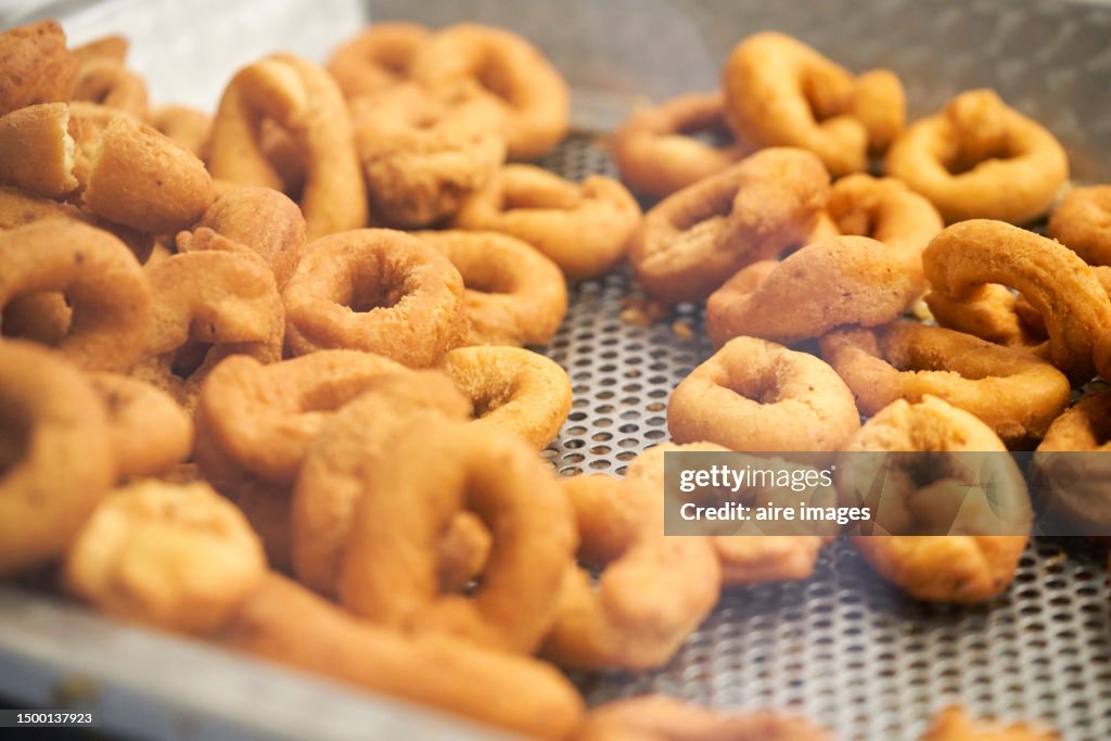 Large group of small fried calamari doughnuts ready to eat in a bowl seen from a high angle window