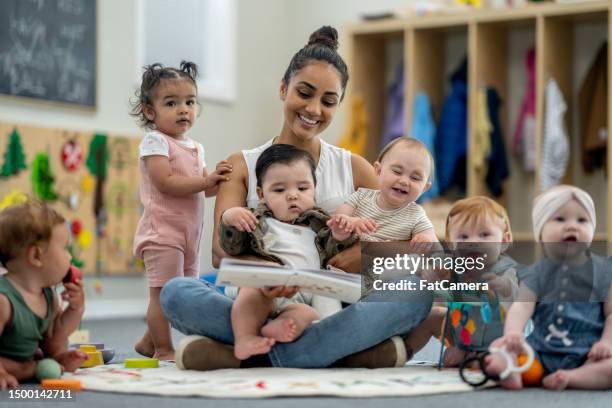 childcareteacher with children - kinderopvang stockfoto's en -beelden