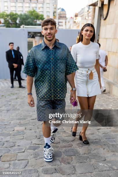 Couple Pierre Gasly wears shirt and shorts with logo print and Francisca Gomes wears white skirt, top outside Louis Vuitton during the Menswear...