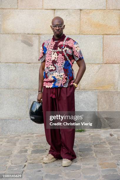 Guest wears shirt with print, rust brown pants outside Louis Vuitton during the Menswear Spring/Summer 2024 as part of Paris Fashion Week on June 20,...