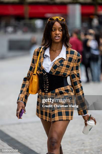Guest wears corset, checkered blazer outside Li-Ning during the Menswear Spring/Summer 2024 as part of Paris Fashion Week on June 20, 2023 in Paris,...