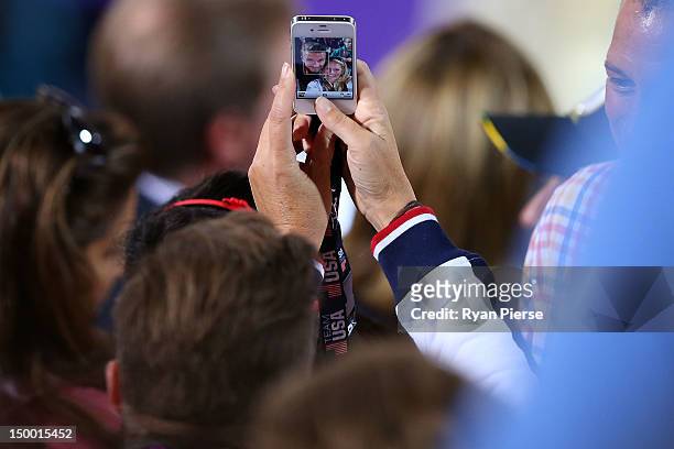 Fan takes a photo of David Beckham on an iphone during the Women's Beach Volleyball Semi Final match between United States and China on Day 11 of the...