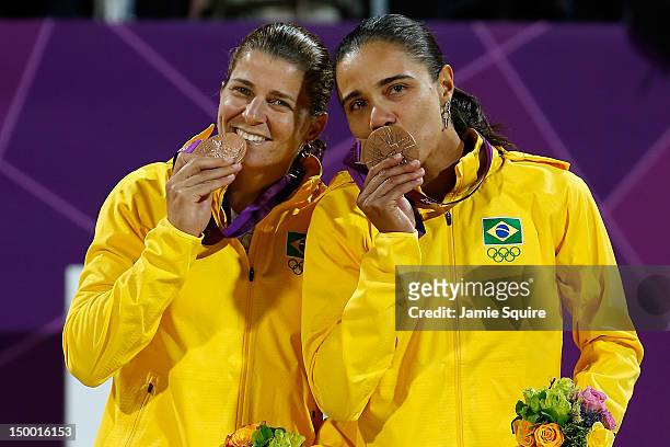 Bronze medallists Larissa Franca and Juliana Silva of Brazil celebrate on the podium during the medal ceremony for the Women's Beach Volleyball on...