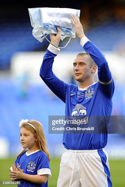 Tony Hibbert of Everton applauds the supporters alongside his daughter prior to the Pre-season Friendly match between Everton and AEK Athens at...