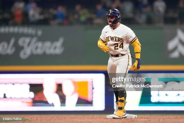 Jesse Winker of the Milwaukee Brewers celebrates in the dugout after hitting a two-run home run against the Arizona Diamondbacks in the fourth inning...