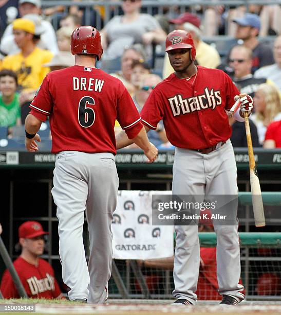 Stephen Drew of the Arizona Diamondbacks celebrates with Justin Upton after scoring on a RBI single in the first inning against the Pittsburgh...