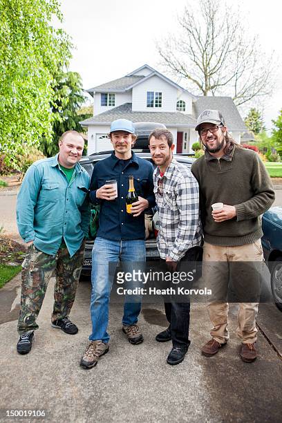 four men share a drink before camping trip. - only mid adult men stock pictures, royalty-free photos & images