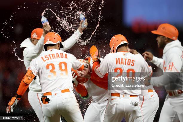 Joc Pederson of the San Francisco Giants is congratulated by teammates after he drew a walk with the bases loaded in the ninth inning to score the...