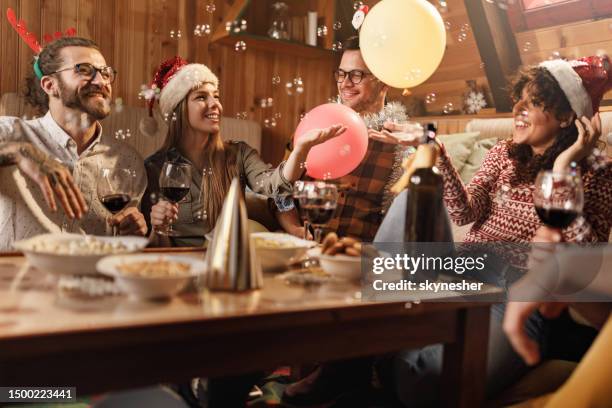 group of happy friends celebrating new year at home. - merry christmas happy new year 2021 stockfoto's en -beelden