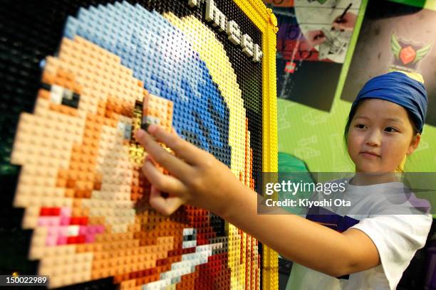 Yuka Takahashi attaches the last piece of Lego bricks to a replica of Johannes Vermeer's 'Girl with a Pearl Earring' for the final touch during an...