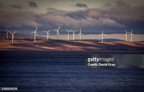 Wind turbines can be seen on hills surrounding Lake George, located near the Australian capital city of Canberra on May 30, 2023 in Australia.