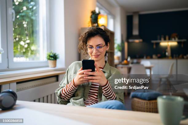 belle jeune femme envoyant des sms sur son téléphone - women chatting photos et images de collection