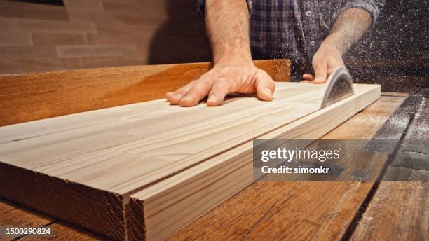 male carpenter's hands cutting wooden plank - table saw stock pictures, royalty-free photos & images