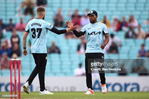 Gus Atkinson of Surrey celebrates with team mate Chris Jordan after taking a wicket during the Vitality T20 Blast match between Surrey CCC and...