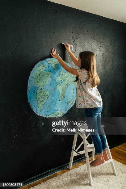 girl drawing earth shape with colorful chalks on a blackboard wall - macedonia map stock pictures, royalty-free photos & images