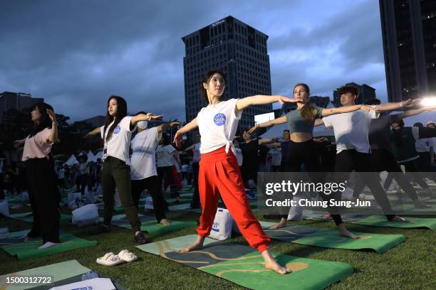 People perform yoga to mark International Day of Yoga in front of Gwanghwamun Gate on June 21, 2023 in Seoul, South Korea. The event was held as part...