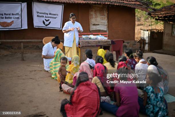 female doctor spreading awareness among rural women on women's health during rural health care camp - indian community stock pictures, royalty-free photos & images