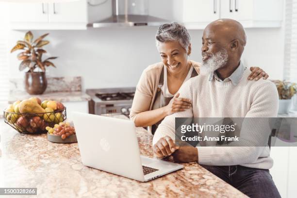 retirement isn't the end, but the beginning of a new life - senior couple laptop stock pictures, royalty-free photos & images