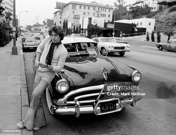 Musician/Actor Brian Protheroe poses with a Hudson Hornet on the Sunset Strip in West Hollywood, CA 1975.