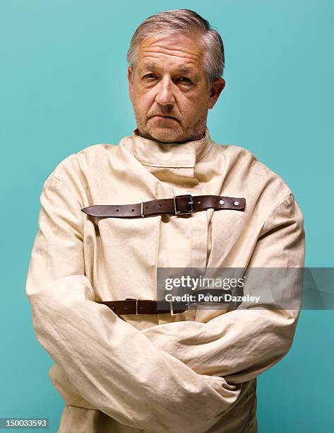 senior man restrained in a straight jacket - straight jacket stock-fotos und bilder