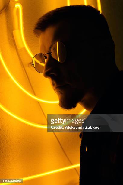 a handsome, confident hipster man on the streets of the city, illuminated by bright neon signs. a student or a young man in a plaid shirt, wearing sunglasses at a party at night, in a nightclub. the nightlife of young people. graduation party. close-up. - cinematic stock pictures, royalty-free photos & images