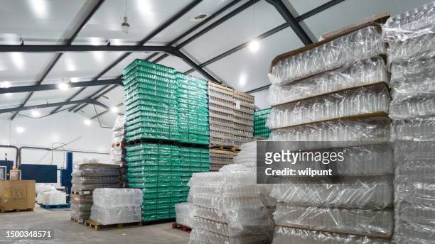 empty plastic bottles stacked inside a water bottling plant warehouse - packaging stock pictures, royalty-free photos & images