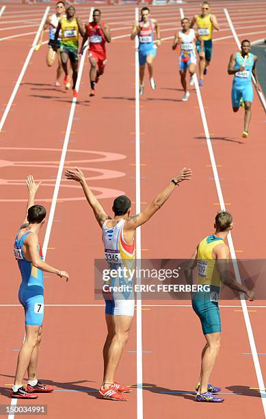 Russia's Vladimir Krasnov, Venezuela's Albert Bravo and Australia's Brendan Cole wait for their teammates in the men's 4X400m relay heats at the...