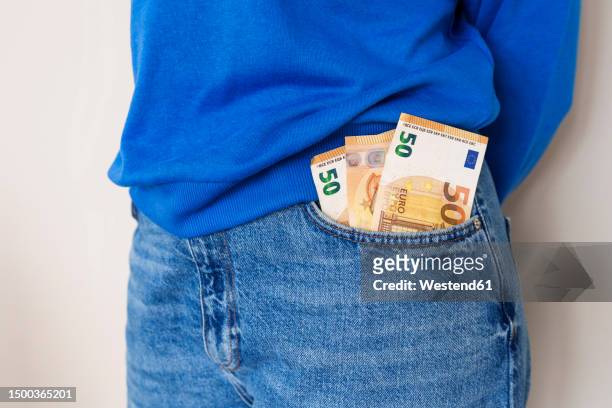 woman with paper currency in jeans pocket - billet de 50 euros photos et images de collection