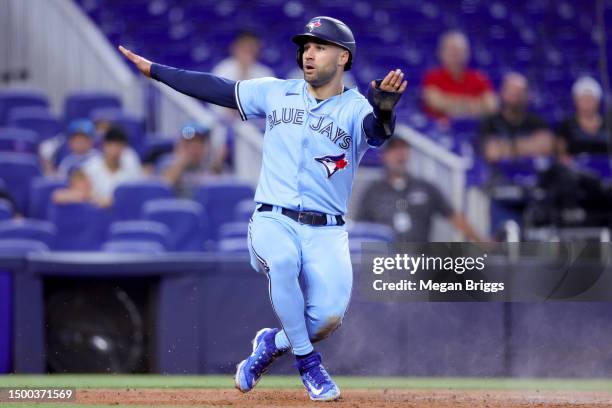 Kevin Kiermaier of the Toronto Blue Jays reacts after sliding home to score a run against the Miami Marlins during the second inning at loanDepot...