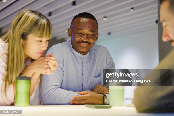 people of various ethnicities are taking a break in the office cafeteria. - makiko tanigawa stock-fotos und bilder