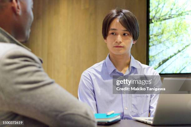 colleagues are talking seriously to each other. in a stylish office cafeteria - makiko tanigawa stock-fotos und bilder