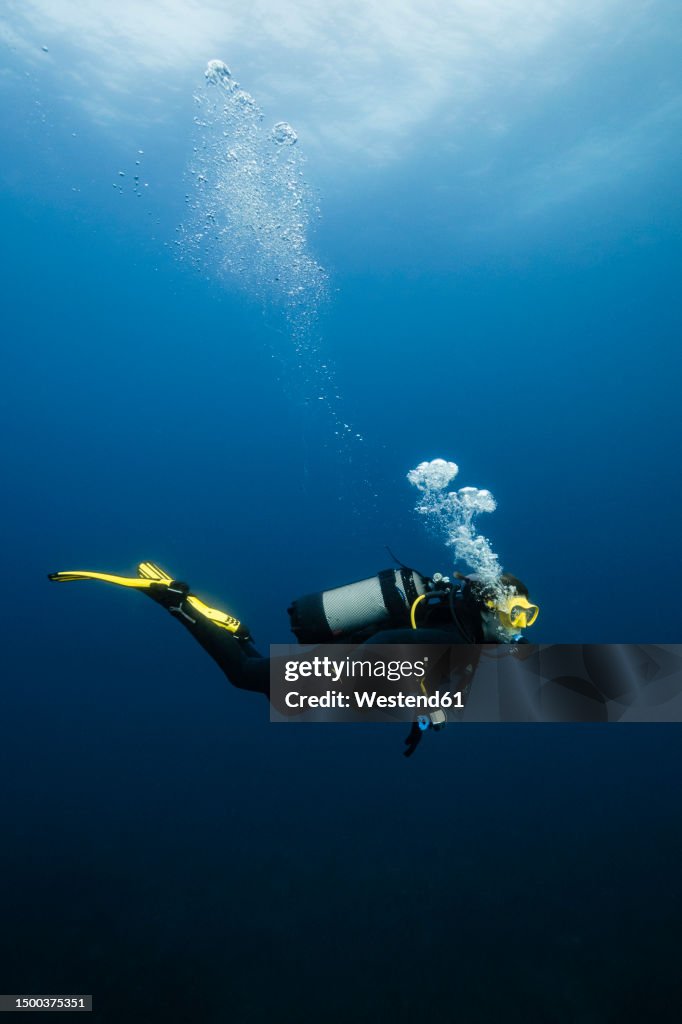 Young woman scuba diving in sea