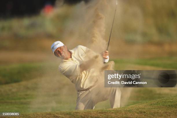 Tom Lehman of the United States hits out of the 18th hole bunker during his round of 64 at the 125th Open Championship on 20tht July 1996 at the...