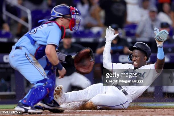 Jesus Sanchez of the Miami Marlins slides home to score a run against the Toronto Blue Jays during the fourth inning at loanDepot park on June 21,...
