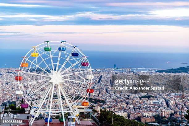 ferris wheel at tibidabo and barcelona skyline, spain - barceloneta fotografías e imágenes de stock