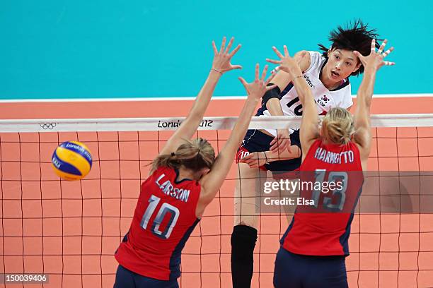 Yeon-Koung Kim of Korea spikes the ball against Jordan Larson and Christa Harmotto of United States during the Women's Volleyball semifinal match on...