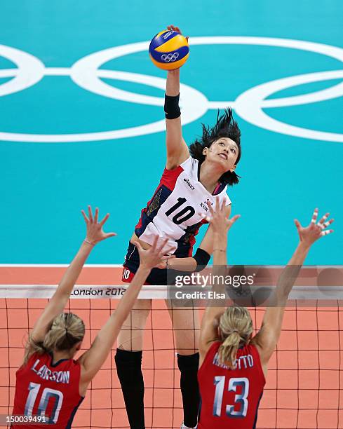 Yeon-Koung Kim of Korea spikes the ball against Jordan Larson and Christa Harmotto of United States during the Women's Volleyball semifinal match on...