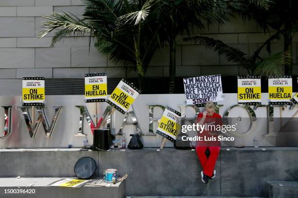 Los Angeles, CA - Picket signs of striking members of the Unite Here Local 11 hotel workers union partially obscure the sign of the JW Marriott Hotel...