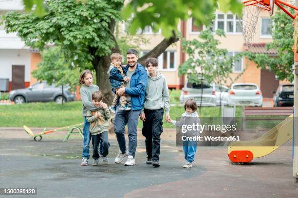 happy father walking with children on playground - family with five children stock pictures, royalty-free photos & images