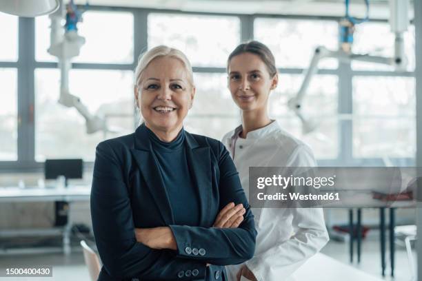 happy businesswoman standing by colleague in laboratory - old laboratory stock pictures, royalty-free photos & images