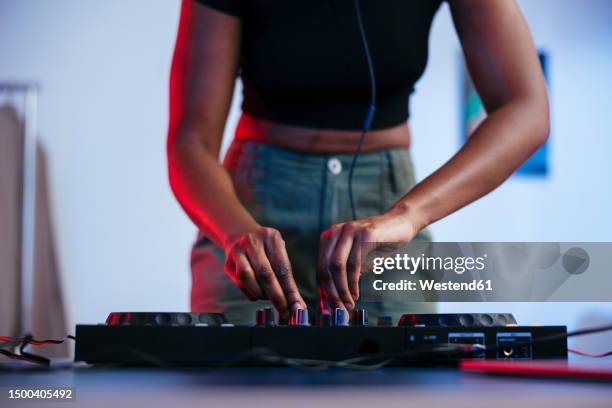 young female dj operating sound mixer at home - mixage du son photos et images de collection