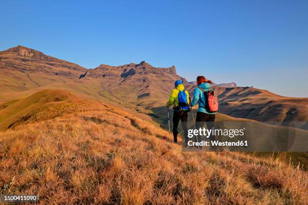 woman and man hiking at kwazulu-natal, drakensberg, south africa - drakensberg mountain range stock pictures, royalty-free photos & images