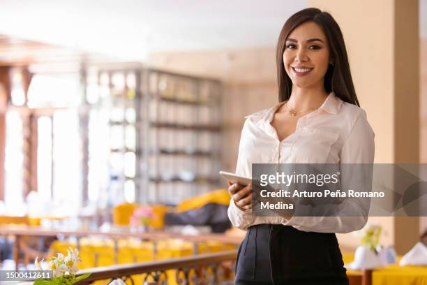portrait of hostess with tablet in hand ready to greet people. - party host 個照片及圖片檔