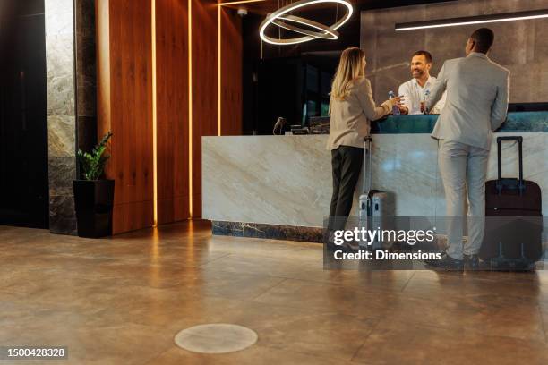 hotel receptionist with two new guest - hotel confirmation stock pictures, royalty-free photos & images