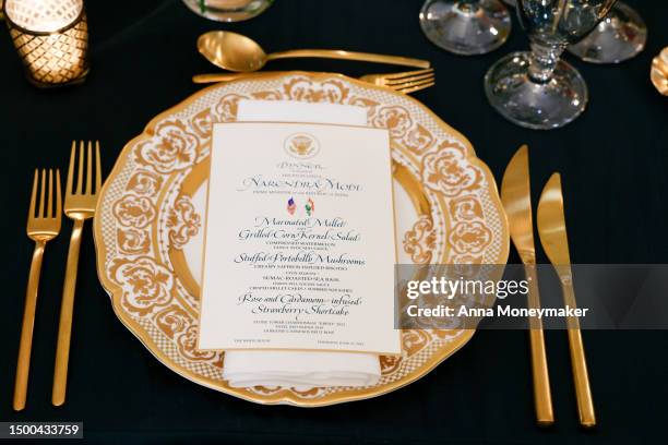 Place settings are displayed at a media preview of the state dinner during a media preview in the State Dining Room of the White House on June 21,...