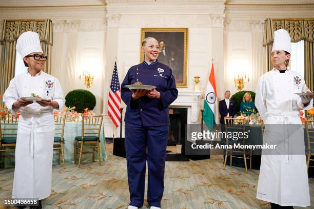 White House Executive Chef Cris Comerford, Guest Chef Nina Curtis, and White House Executive Pastry Chef Susie Morrison hold up dishes during a media...