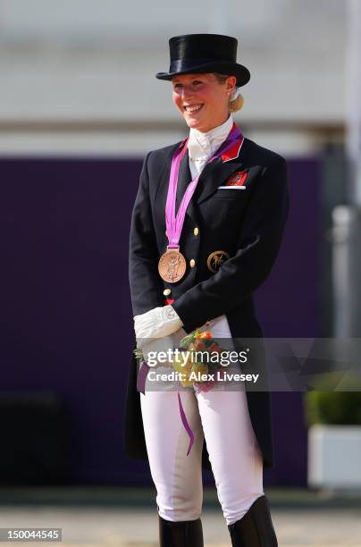 Laura Bechtolsheimer of Great Britain riding Mistral Hojris celebrates with her bronze medal during the medal ceremony following the Individual...